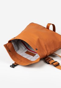 Orangener Rucksack mit flachem Design, ausgestattet mit einer strukturierten Außenseite, Stofffutter, Innenfach mit rotem Reißverschluss und verstellbarem Schulterriemen.