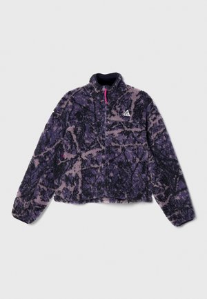 Purple and black fleece jacket with a high collar, zip front, and abstract pattern. Features a logo on the left chest and textured fabric.