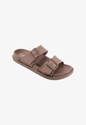 Bruine rubberen slippers met twee verstelbare gespen en een gestructureerde zool voor grip, getoond op een witte achtergrond.