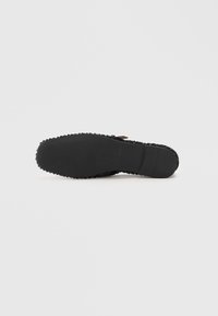 Semelle en caoutchouc noire avec une surface texturée, présentant de petits motifs en relief et un bord lisse. Design plat sans aucune marque visible.