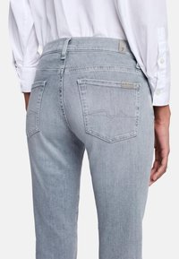 Lichtgrijze spijkerbroek met een mid-rise taille, vijf zakken en subtiele stiksel details. Gemaakt van denim stof, met een label op de achterzak.