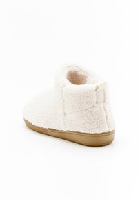 Stivale alla caviglia in fleece crema con una texture morbida, punta arrotondata, suola flessibile e un piccolo risvolto in tessuto sul tallone per una facile calzata.
