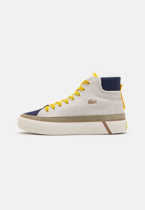 High-Top-Sneaker aus strukturiertem cremefarbenem Stoff mit marineblauer Spitze und Knöchelpartie, gelben Schnürsenkeln, olivgrüner Einfassung und strukturierter weißer Sohle.