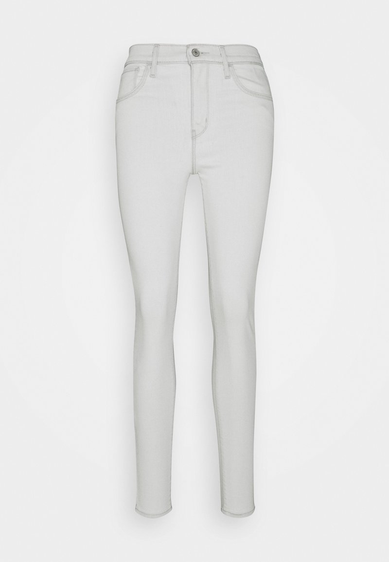Vaqueros skinny de un gris claro, hechos de denim. Con tiro alto, cinco bolsillos y cierre de botón plateado en la parte frontal. Textura suave.