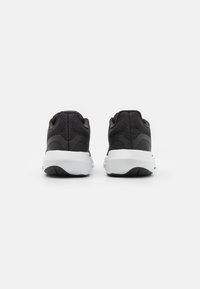 Scarpe da corsa nere con tomaia testurizzata, colletto imbottito e suola intermedia bianca. Presentano una suola in gomma nera e un design minimalista.