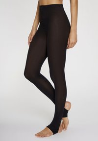 Schwarze Leggings mit hohem Bund, gerippter Textur und Knöchelschlitzen. Glatter Stoff mit figurbetontem Design.