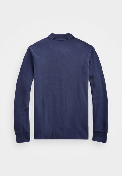 Polo de manga larga azul marino con tejido texturizado, cuello doblado y mangas con puños, que presenta un diseño simple y limpio sin logotipos visibles.