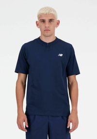 Navy blue short-sleeve shirt with a henley collar, featuring a subtle logo on the left chest. Smooth texture, athletic fit.