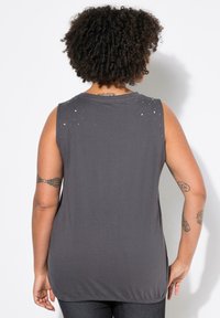 Top grigio senza maniche con scollatura rotonda, caratterizzato da dettagli decorativi sulle spalle e una vestibilità rilassata. Tessuto morbido con una consistenza liscia.
