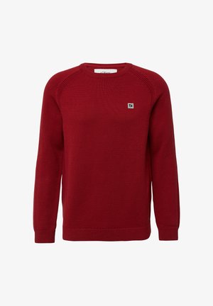 Red crewneck knit sweater with long sleeves and small square logo patch on left chest.