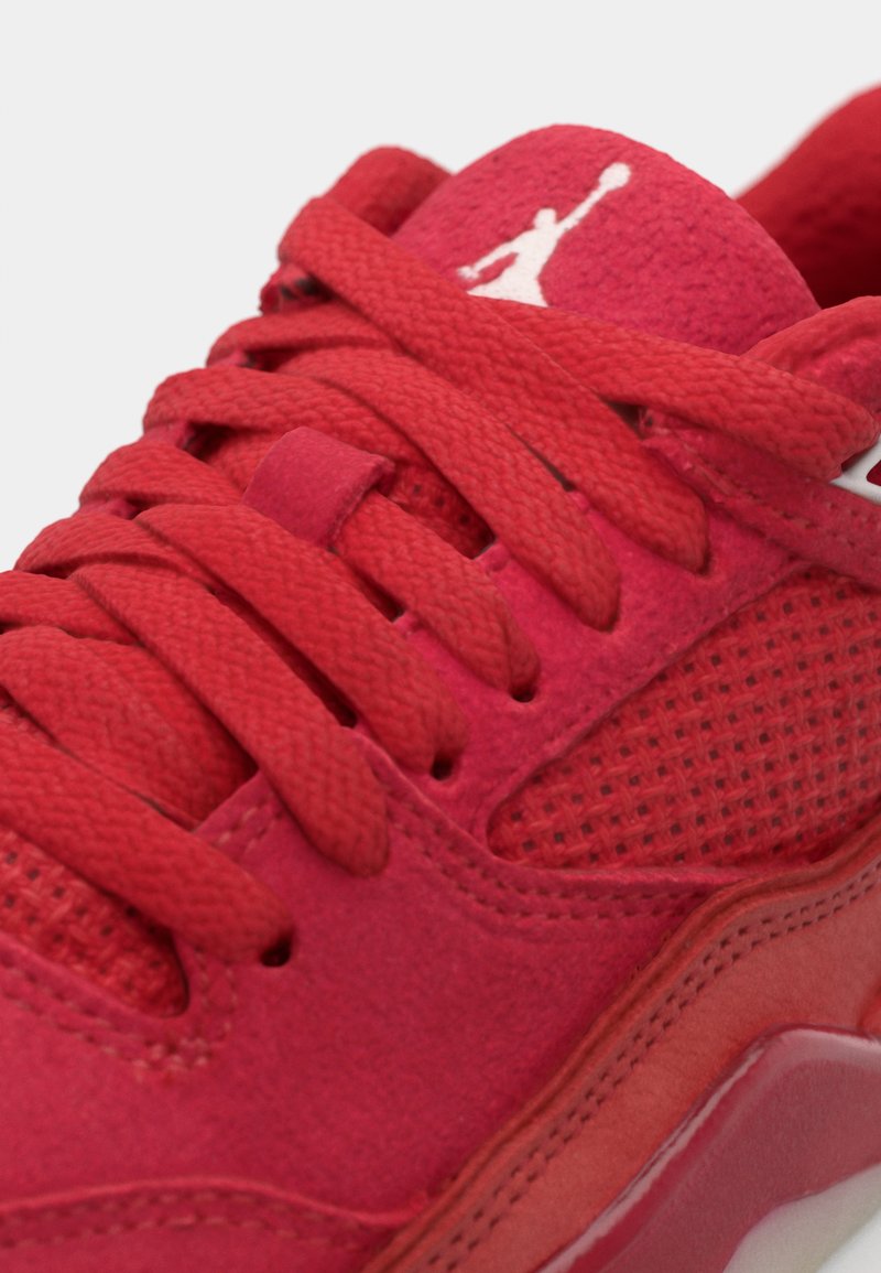 Zapatilla roja con parte superior de ante y paneles de malla, cordones redondos y suela de goma. Acabada con un logo blanco en la lengüeta.