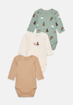 Trois bodies bébé à manches longues : un vert avec des imprimés de chiens, un blanc avec deux illustrations de chiens et un beige uni, disposés à plat sur un fond blanc.