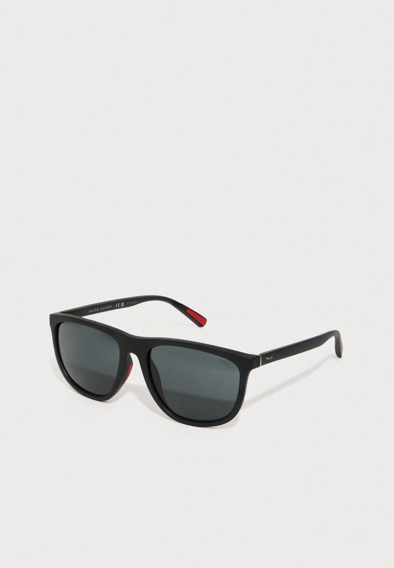 Black sunglasses with grey lenses, rectangular shape, black plastic frame, red accents on the temples, and "POLO" logo on the side.