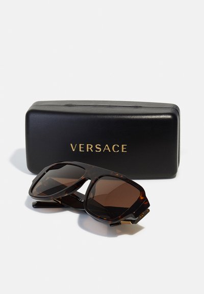 Ochelari de soare Versace cu ramă de broască țestoasă, lentile maro și accente aurii, însoțiți de un etui rigid negru cu numele brandului.