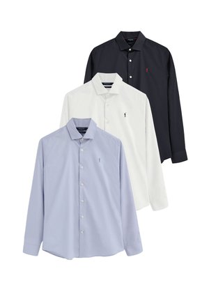 Tres camisas de manga larga con botones en azul claro, blanco y negro con pequeños logos bordados en el pecho.
