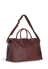 Bruine leren duffelbag met twee handvatten bovenaan, een verstelbare schouderriem, zilverkleurige hardware en een gestructureerde afwerking. Zipper sluiting zichtbaar.