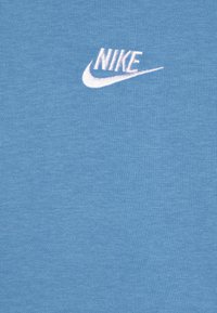 Tricou din bumbac albastru, cu un logo Nike brodat alb pe partea stângă sus, având o textură netedă și uniformă.