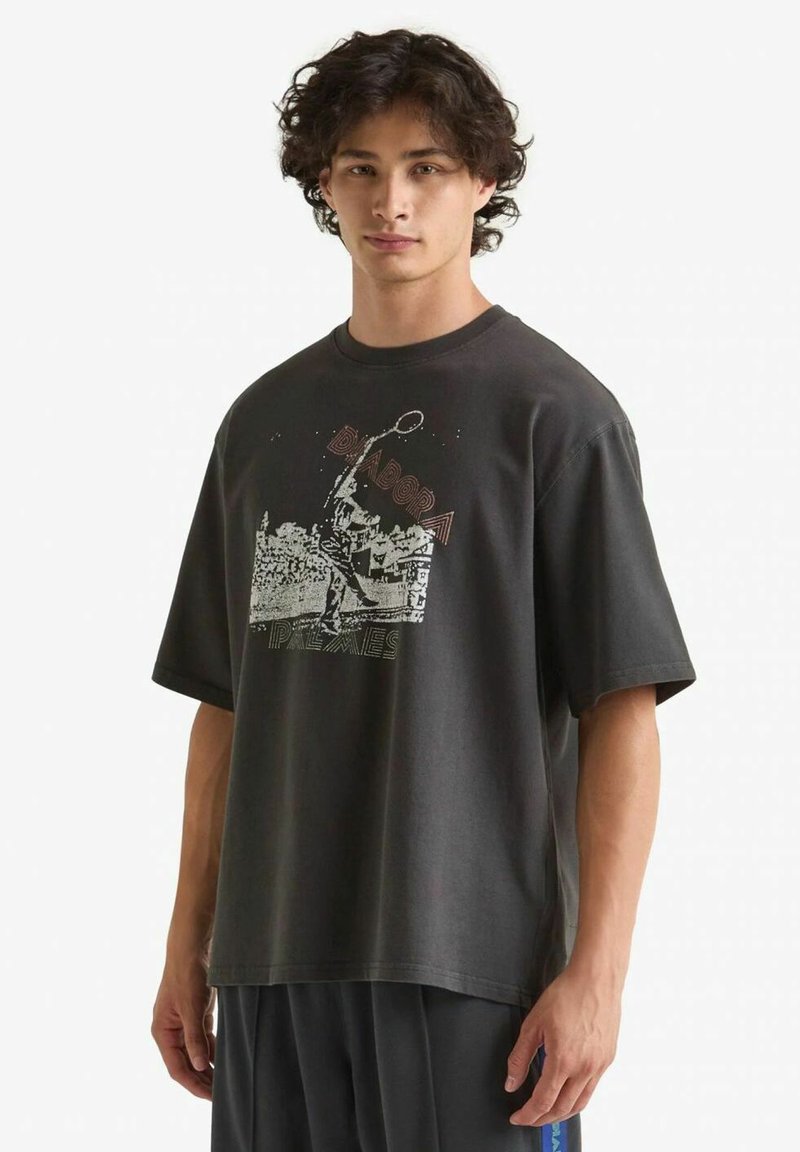 T-shirt nera in cotone con vestibilità ampia, dotata di stampa grafica in argento e arancione. Collo tondo e maniche corte, texture minimale.