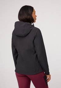 Black softshell jacket with a hood, fitted design, and smooth texture. Features a mandarin collar and back seam detailing.