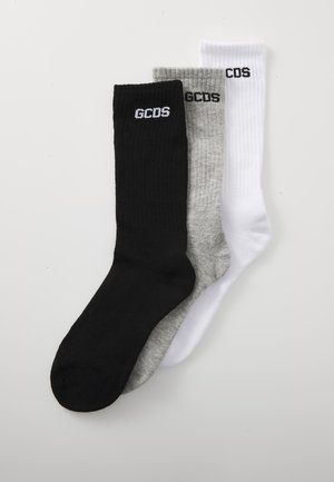 Tres pares de calcetines de algodón acanalado en negro, gris y blanco, con el logotipo bordado "GCDS" cerca de la parte superior. Altura estándar de caña.