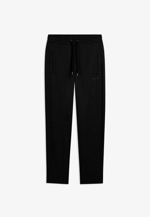 Pantalons de survêtement ajustés noirs avec taille élastique, cordon de serrage, poches latérales et logo discret sur la cuisse droite, posés à plat sur un fond blanc.