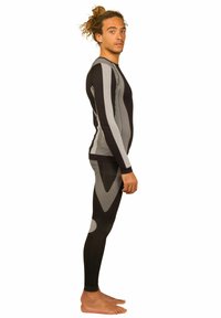 Schwarzer und grauer Sportanzug mit einer taillierten Passform. Das langärmlige Oberteil weist Streifenmuster auf; die Leggings haben ein geometrisches Muster und Akzente.