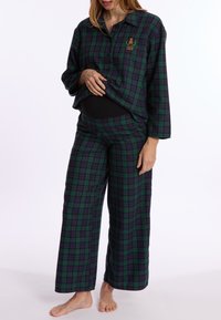 Groene en paarse geblokte pyjama set met een knoopsluiting shirt en wijde broekspijpen. Zachte stof met geborduurd detail op het shirt.
