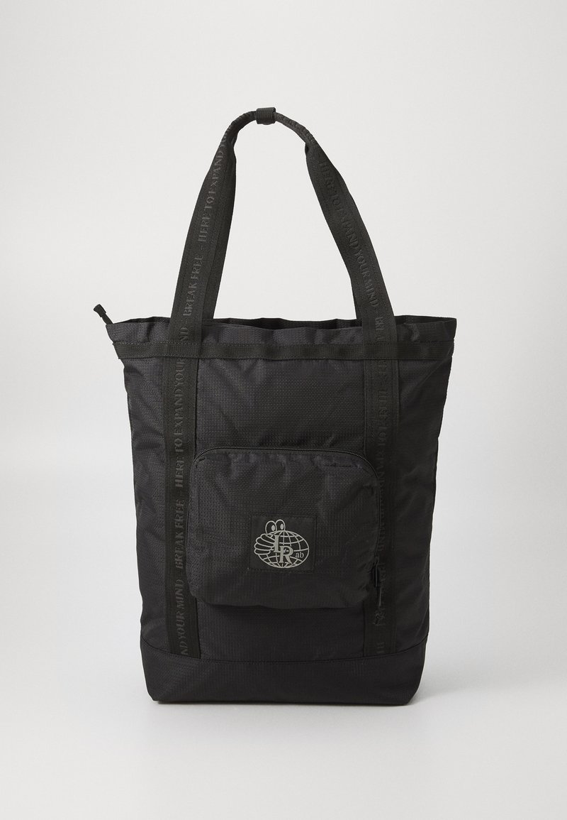Black tote bag made of textured fabric, featuring two handles and a front zip pocket with a graphic logo. Accented with black straps.