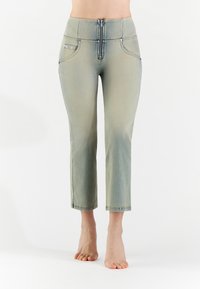 Pantaloni capri in denim verde chiaro con zip frontale, due tasche anteriori e vita aderente. Il tessuto ha una leggera texture sbiadita.