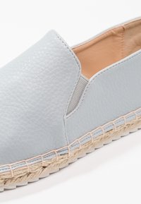 Bottines espadrilles bleu clair avec tige en cuir texturé et panneaux latéraux élastiques. Semelle intermédiaire en jute naturel avec des coutures contrastantes.