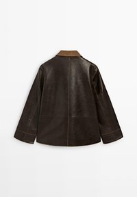 Veste en cuir marron avec un col marron, présentant un design droit, des manches larges et des détails de coutures visibles au dos.