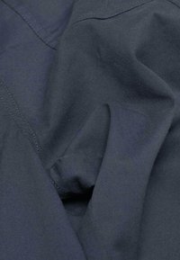 Marine stof met een zachte textuur, met lichte kreuken en zichtbare stiksels, die een zachte val en een eenvoudige uitstraling vertoont.