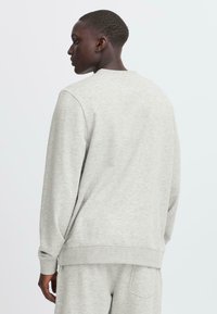 Gray cotton sweatshirt, featuring a round neck, long sleeves, and ribbed cuffs. Smooth texture with a relaxed fit, showing the back view.