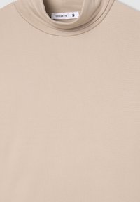 Maglione a collo alto beige realizzato in tessuto morbido, con un design aderente e una texture sottile. L'etichetta mostra la taglia "S" del marchio Terranova.