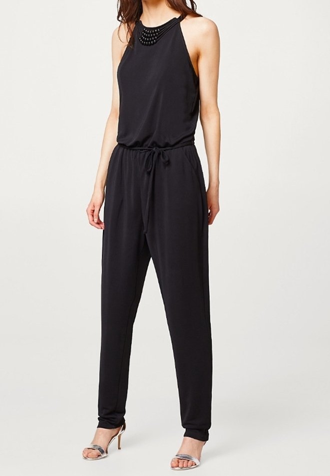 Black sleeveless jumpsuit with a fitted waist and loose legs. Features a textured neckline with embellishments, made from a smooth fabric.
