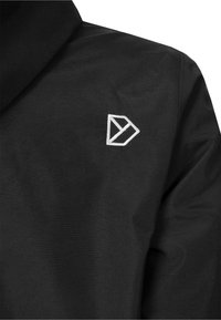 Chaqueta de tela negra con un pequeño logo geométrico blanco bordado en el área izquierda del pecho.