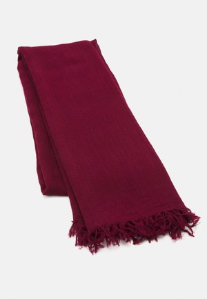 Bordeauxfärgad scarf tillverkad av mjukt tyg, med en fransad kant och en slät yta. Rektangulär form, vikt snyggt.
