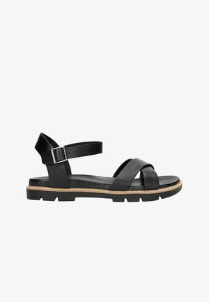 Schwarze Ledersandale mit einem Kreuzriemen-Design, verstellbarem Knöchelliemen mit silberner Schnalle und einer strukturierten schwarzen Sohle mit beigen Akzenten.