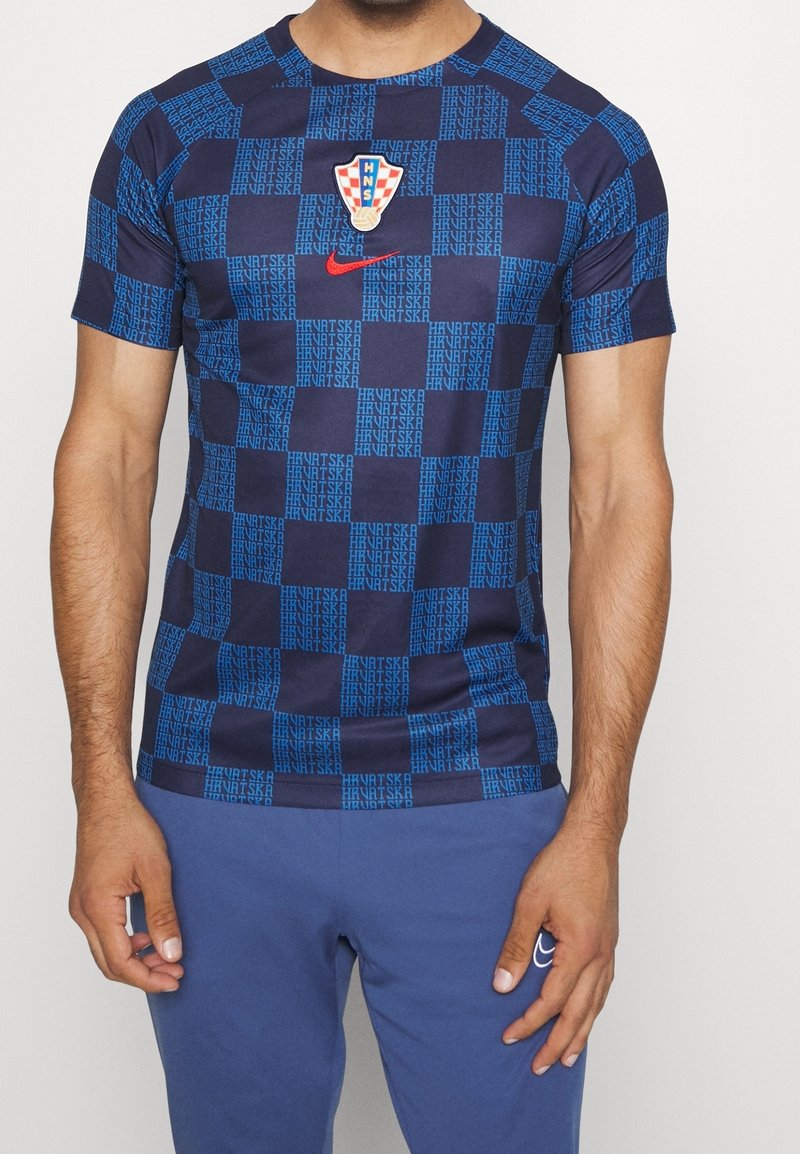 Blå och marinblå mönstrad t-shirt i lättviktigt material, med ett kroatiskt fotbollsmärke och en Nike-logga på bröstet.