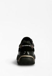 Black sneaker with a textured suede upper and glossy accents. Features a contrasting gold line near the sole and branded heel strap.