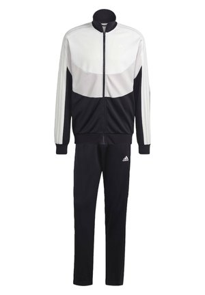 Chándal Adidas en blanco y negro que incluye una chaqueta con cremallera y cuello alto, además de pantalones negros. La chaqueta presenta un diseño en bloques de color y tres franjas.
