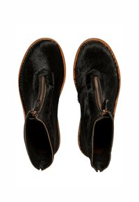 Botas negras de cuero hasta el tobillo con un acabado texturizado, que cuentan con un zipper lateral, suelas marrones y una punta redondeada.