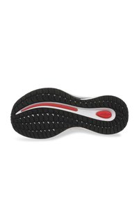 Suela de sneaker de goma negra con agarre texturizado, que presenta una franja de acento blanca y roja y un diseño liso y curvado.