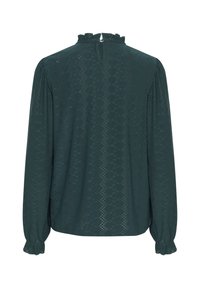 Dunkelgrüne Bluse mit langen Ärmeln, rüschigem Ausschnitt und filigranen Ausstanzungen. Gathering an den Manschetten und keyhole-Verschluss auf der Rückseite.