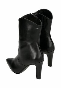 Stivali neri in pelle a metà polpaccio con punte appuntite, tacchi alti, cerniere laterali e un piccolo logo metallico sulla parte esterna dello stivale.