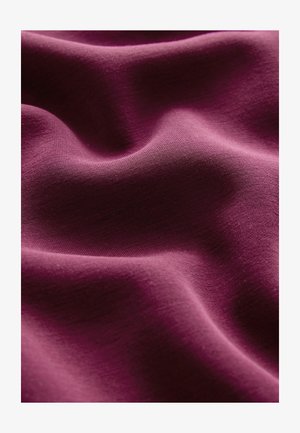 Burgundia kangas sujuva tekstuuriga, millel on pehmed lained ja voldid, rõhutades materjali venivust ja pehmust.