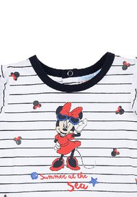 Camisa de manga corta a rayas blancas con un gráfico de un personaje de dibujos animados en rojo y negro, con el texto "Verano en el Mar" en letra cursiva roja.