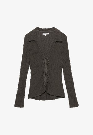 Haut à manches longues texturé gris foncé avec un col, décolleté en V et détail de cravate à l'avant. Présente une silhouette fluide et un tissu délicatement froncé.