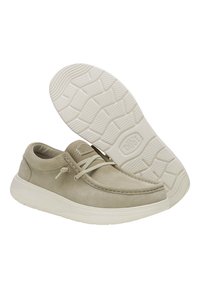 Zapatos de ante beige con punta redonda y detalles de cordones, suela blanca elevada con textura para ofrecer agarre.