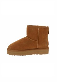 Stivale alla caviglia color tan in suede con punta arrotondata, cuciture minime e suola in gomma. Presenta una piccola cerniera sul retro per una migliore accessibilità.